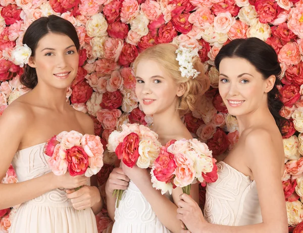 Three women with background full of roses — Stock Photo, Image