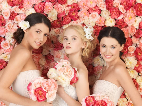 Tři ženy s pozadím plné růží — Stock fotografie