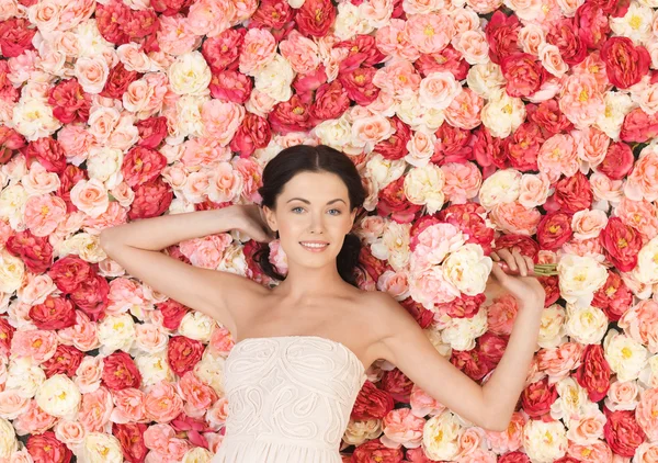 Mujer con ramo y fondo lleno de rosas — Foto de Stock