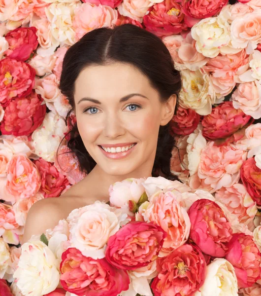 Mujer con fondo lleno de rosas — Foto de Stock