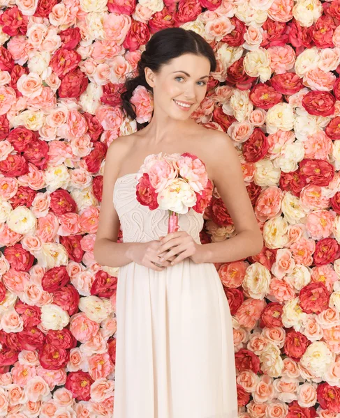 Femme avec bouquet et fond plein de roses — Photo