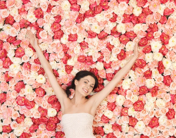 Giovane donna con sfondo pieno di rose — Foto Stock