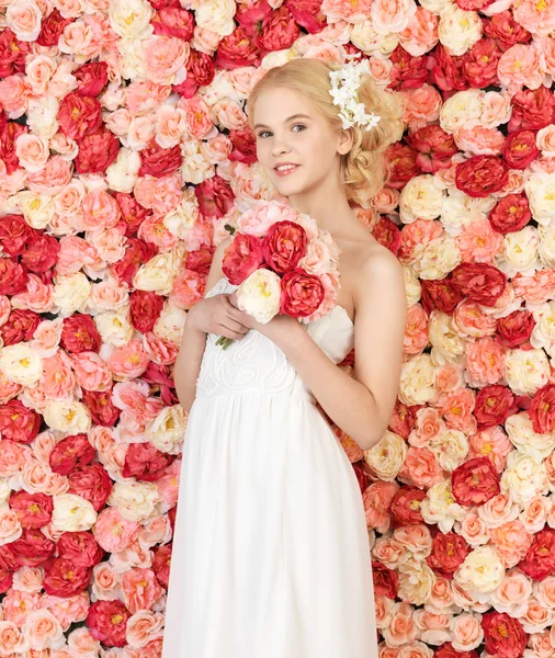 Femme avec bouquet et fond plein de roses — Photo