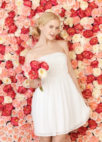 Femme avec bouquet et fond plein de roses — Photo