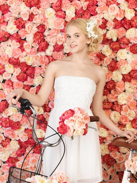 Mulher com bicicleta e fundo cheio de rosas — Fotografia de Stock