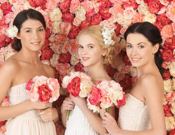 Three women with background full of roses Stock Photo