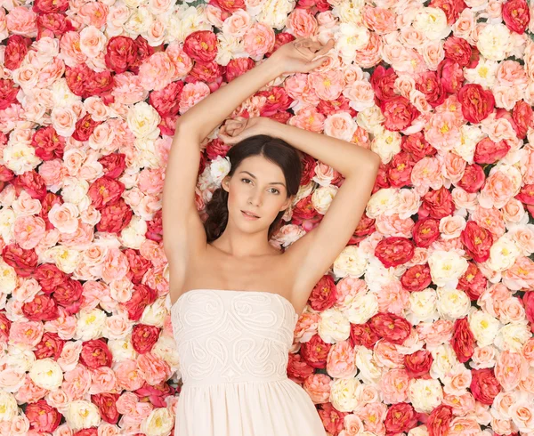 Young woman with background full of roses Stock Photo