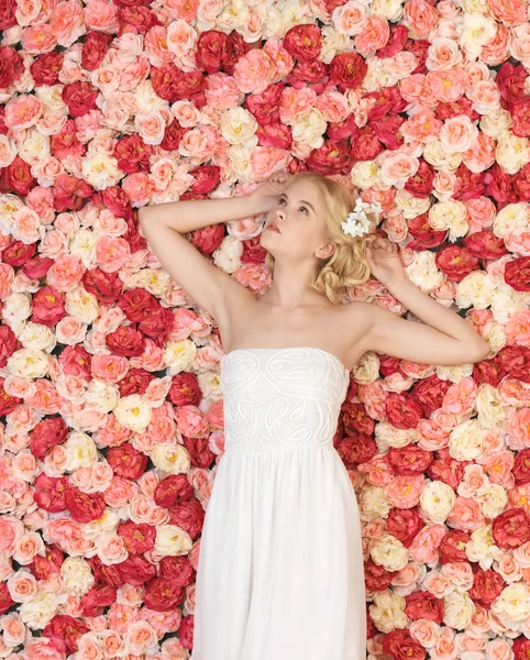 Young woman with background full of roses Stock Image