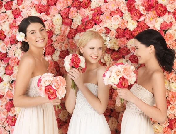 Three women with background full of roses — Stock Photo, Image