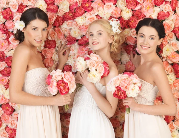 Three women with background full of roses — Stock Photo, Image