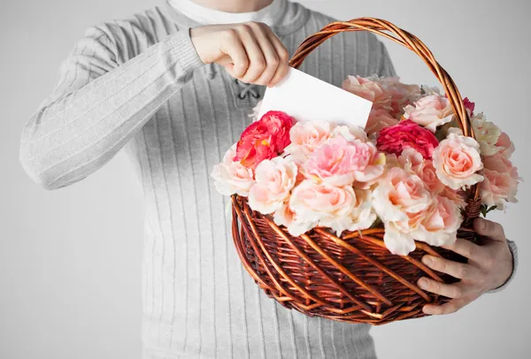Man med korg full av blommor och vykort Royaltyfria Stockfoton