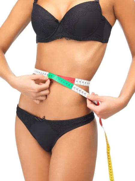 Mujer midiendo su cintura con cinta métrica — Foto de Stock