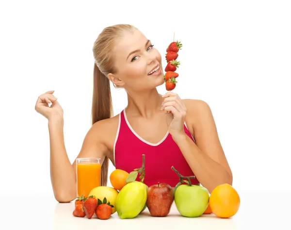 Mujer con comida ecológica comiendo fresa — Foto de Stock