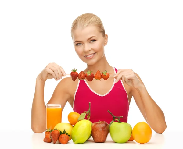 Woman with organic food eating strawberry — Stockfoto