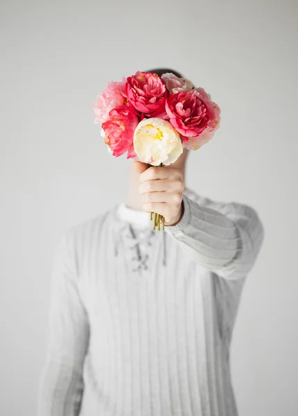 Uomo che si copre il viso con mazzo di fiori — Foto Stock