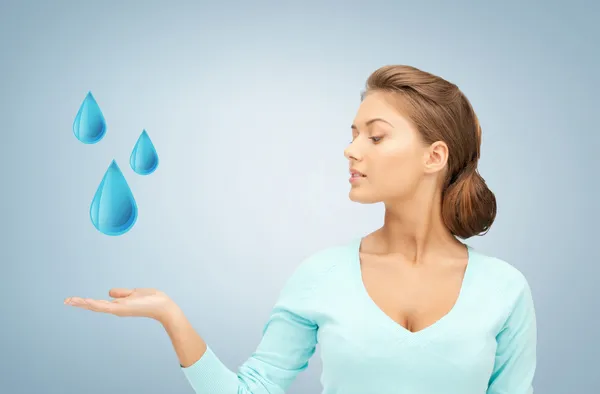 Mulher mostrando gotas de água azul — Fotografia de Stock