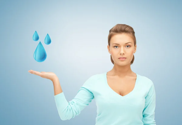 Mulher mostrando gotas de água azul — Fotografia de Stock