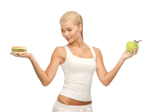Vrouw met apple en hamburger — Stockfoto