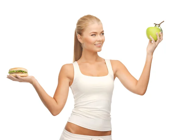 Kobieta z jabłkiem i hamburgerów — Zdjęcie stockowe