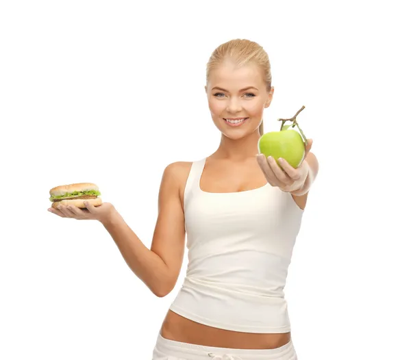 Vrouw met apple en hamburger — Stockfoto