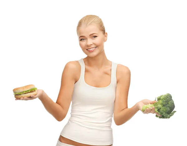 Vrouw met broccoli en hamburger — Stockfoto