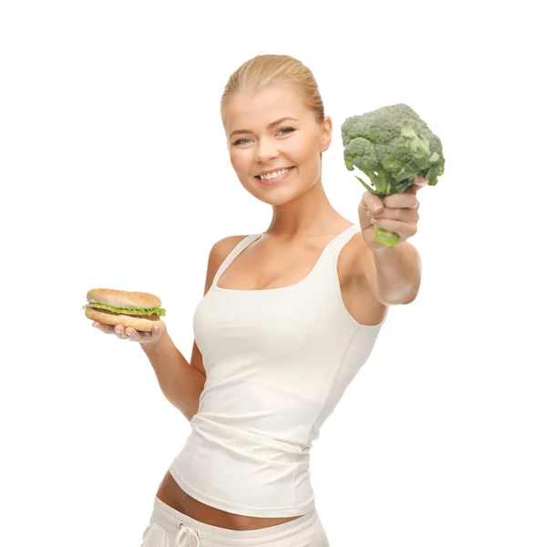Femme avec brocoli et hamburger — Photo