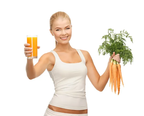 Kobieta trzyma kieliszek soku i marchewki — Zdjęcie stockowe