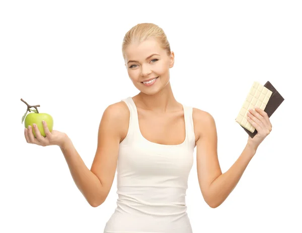 Sportieve vrouw met apple en chocolade bars — Stockfoto