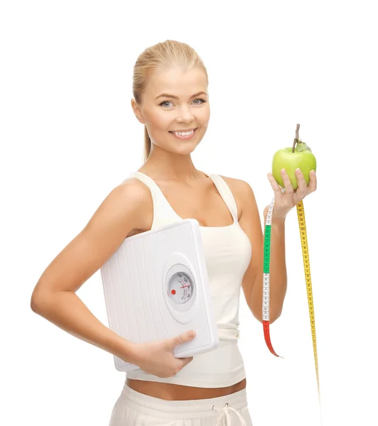Mujer deportiva con escala, manzana y cinta métrica —  Fotos de Stock