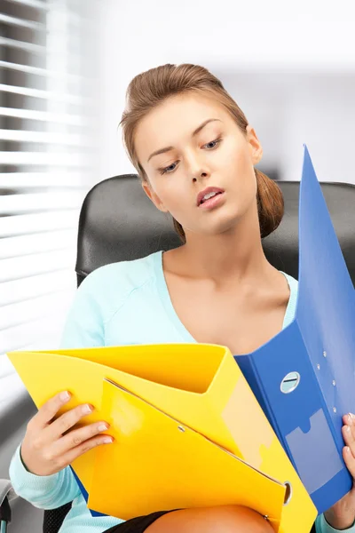 Young businesswoman with folders sitting in chair — Stock Photo, Image