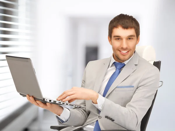Młody biznesmen, siedząc w fotelu z laptopa — Zdjęcie stockowe