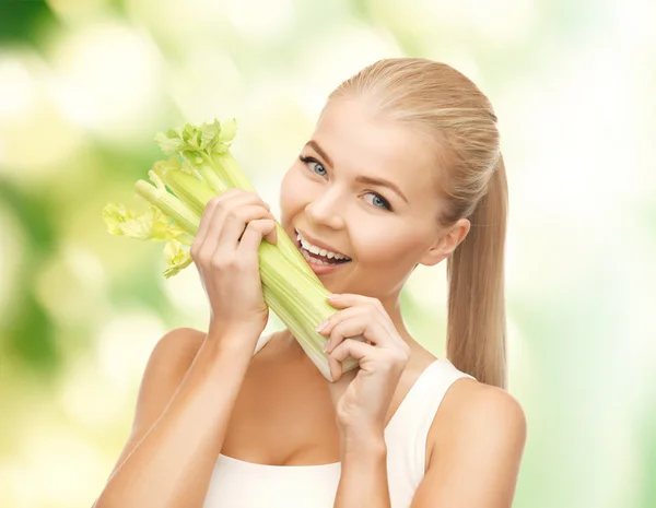 Mujer mordiendo pedazo de apio o ensalada verde — Foto de Stock