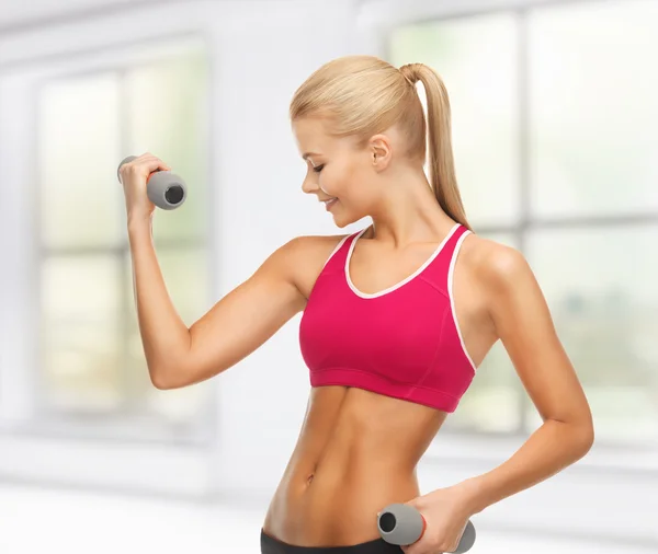 Young sporty woman with light dumbbells — Stock Photo, Image