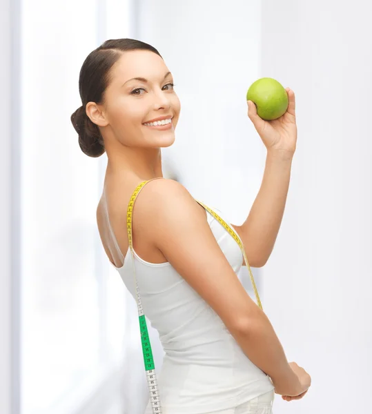 Sportiga kvinnan med äpple och måttband — Stockfoto