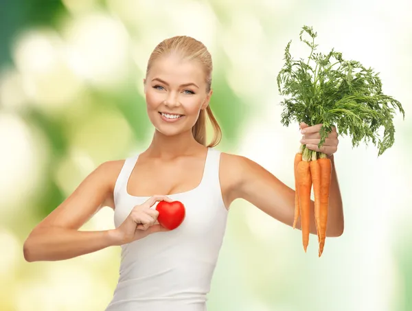 Vrouw met hartsymbool en wortelen — Stockfoto