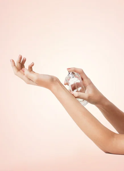 Mujer manos rociando perfume — Foto de Stock