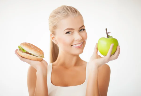 Frau mit Apfel und Hamburger — Stockfoto