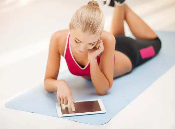 Frau liegt mit Tablet-PC auf dem Boden — Stockfoto