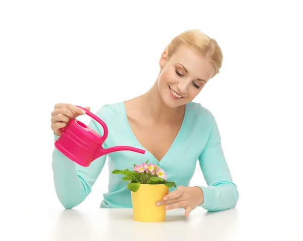 Housewife with flower in pot and watering can — Stock Photo, Image