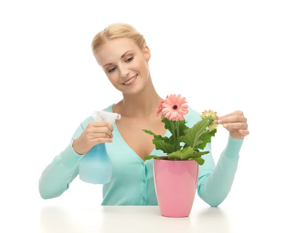 Γυναίκα, κρατώντας το δοχείο με το λουλούδι και σπρέι μπουκάλι — Φωτογραφία Αρχείου