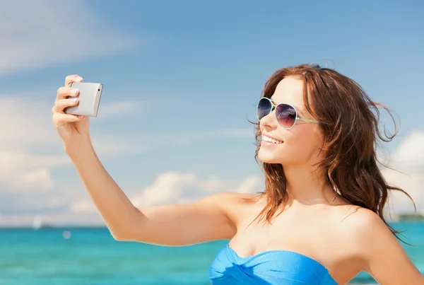 Kvinna i bikini med telefon — Stockfoto