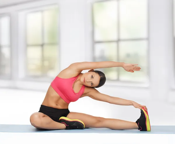 Sportiga kvinnan gör övning på golvet — Stockfoto