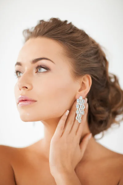 Žena nosí lesklé diamond náušnice — Stock fotografie