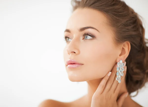 Kvinna som bär glänsande diamantörhängen — Stockfoto
