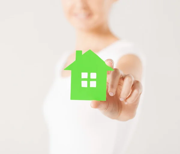 Kobieta ręce, trzymając zielony dom — Zdjęcie stockowe