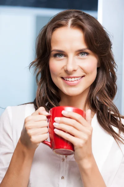 Femme souriante avec tasse rouge — Photo