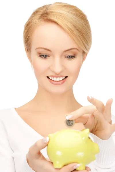 Woman with small piggy bank and coin — Stock Photo, Image