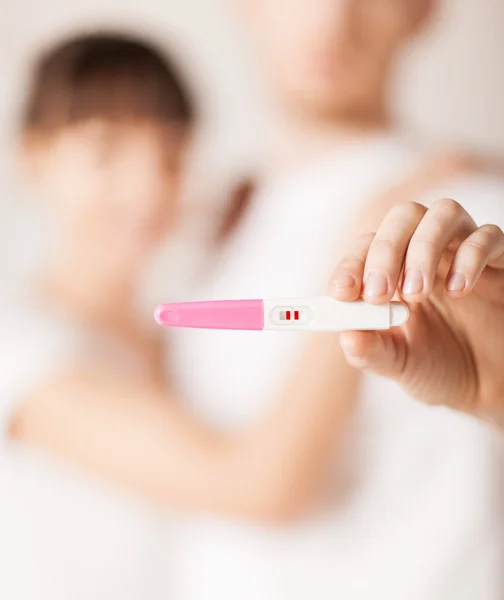 Vrouw en man handen met zwangerschapstest — Stockfoto