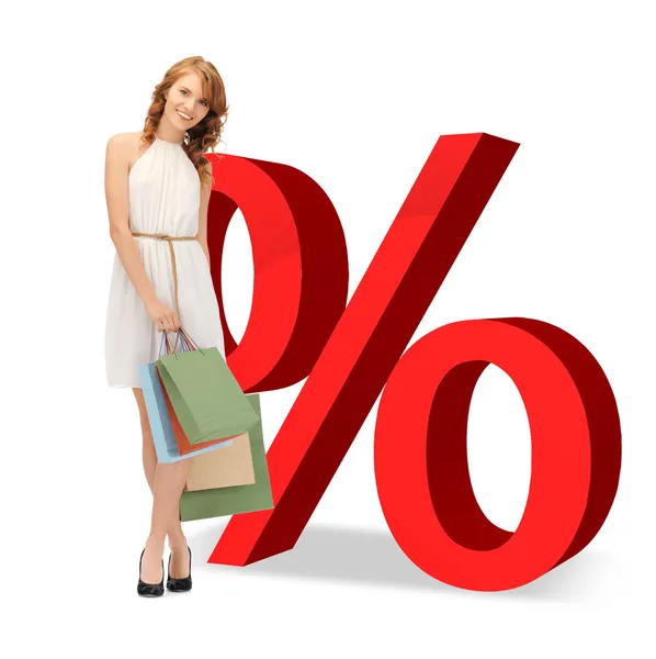 Mulher com sacos de compras e sinais por cento — Fotografia de Stock