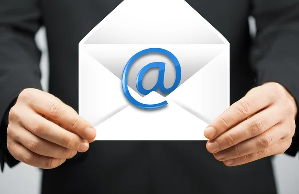 Homem de terno segurando envelope com sinal de e-mail — Fotografia de Stock